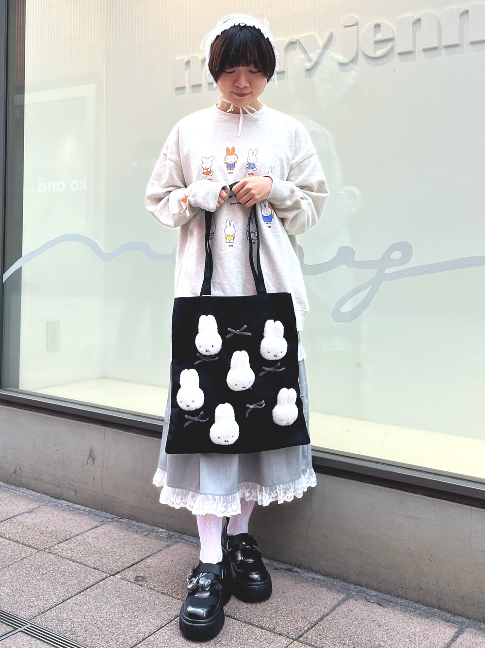 グレー系のスウェット、グレー系のスカート、ブラック系のスニーカーを着用したレディースの冬コーディネートの1枚目の写真