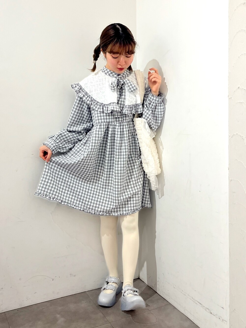 グレー系のワンピース、ホワイト系のトートバッグ、ブルー系のスニーカーを着用したレディースの春コーディネートの1枚目の写真