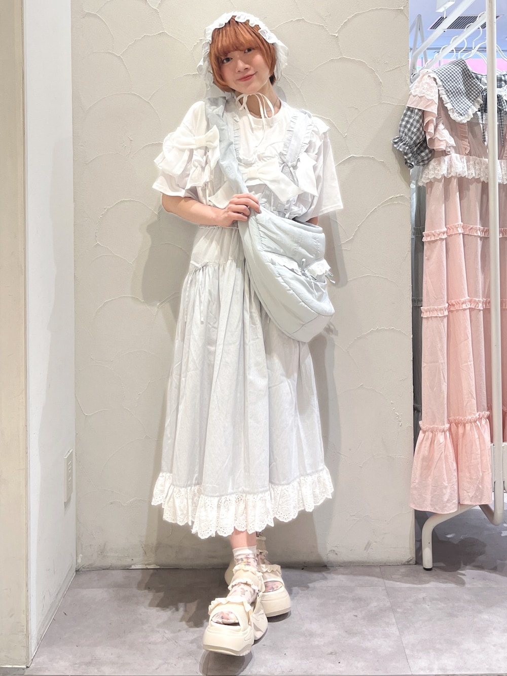 ブルー系のショルダーバッグ、ホワイト系のTシャツ/カットソー、ブルー系のジャンパースカートを着用したレディースの夏コーディネートの1枚目の写真