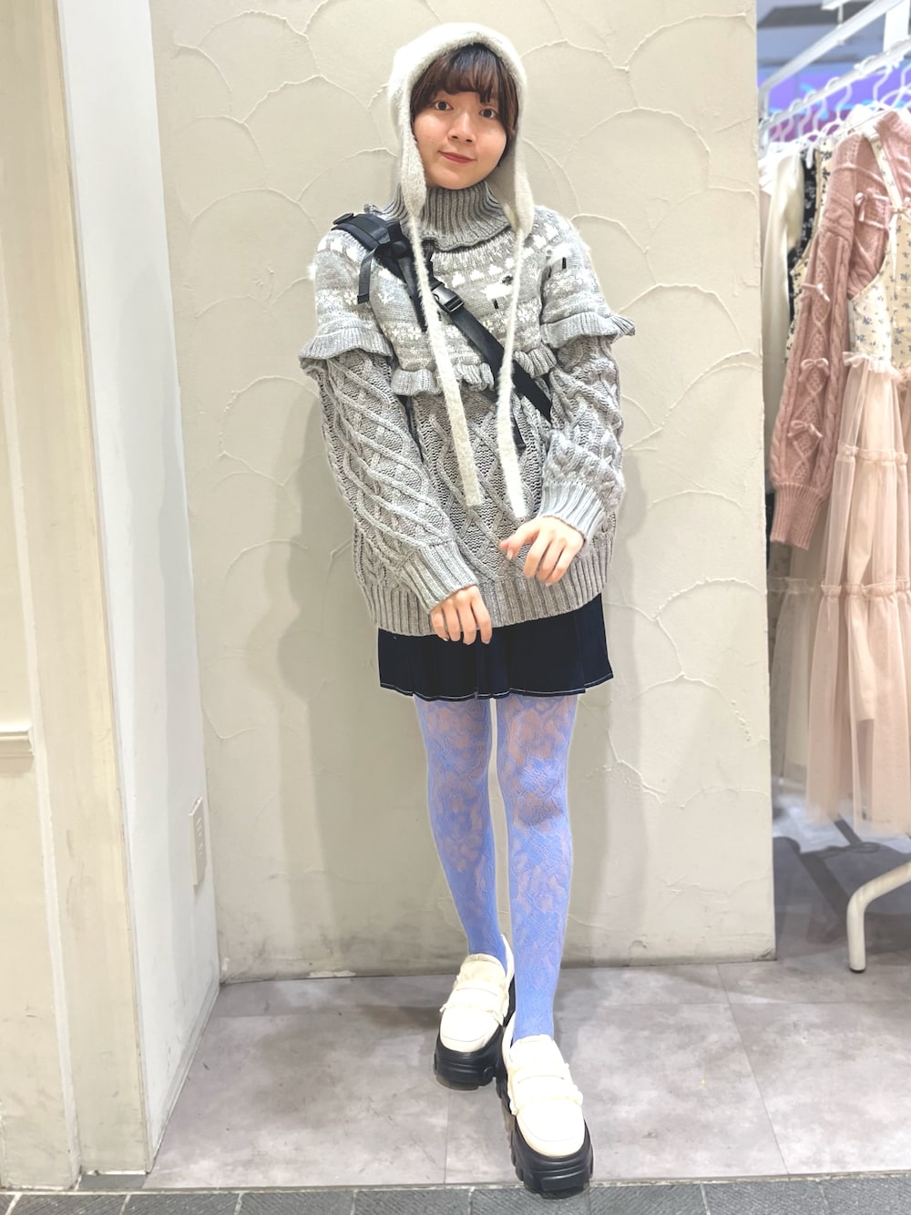 ホワイト系のローファー、グレー系のニット/セーター、ブラック系のショルダーバッグを着用したレディースの冬コーディネートの1枚目の写真