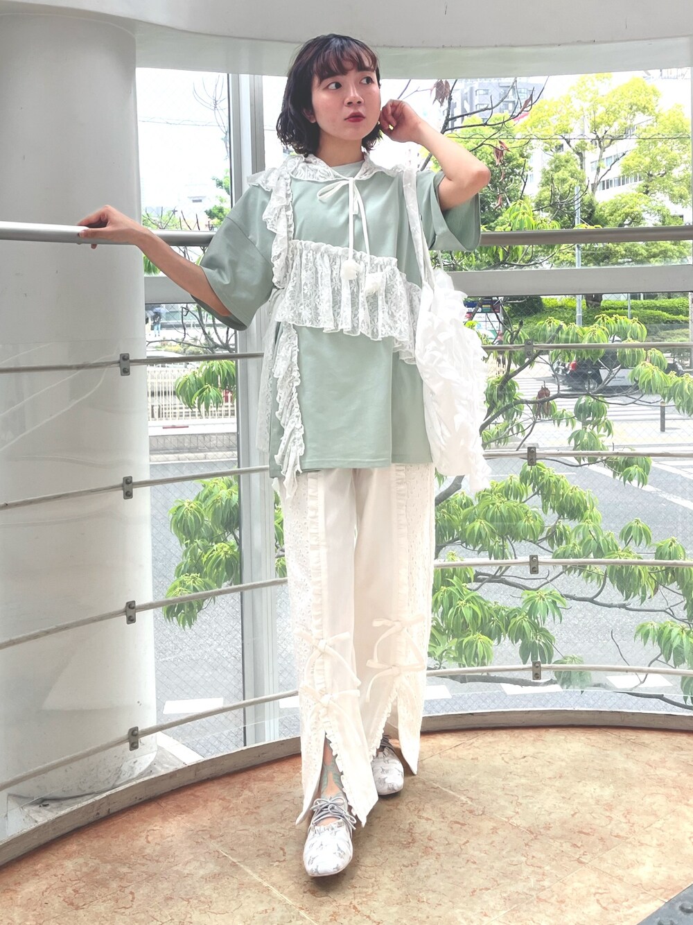 グリーン系のTシャツ/カットソー、ホワイト系のトートバッグ、ホワイト系のデニムパンツを着用したレディースの春コーディネートの1枚目の写真