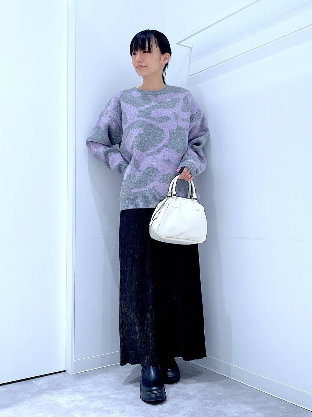 ブラック系のブーツ、グレー系のニット/セーター、ブラック系のスカートを着用したレディースの冬コーディネートの1枚目の写真