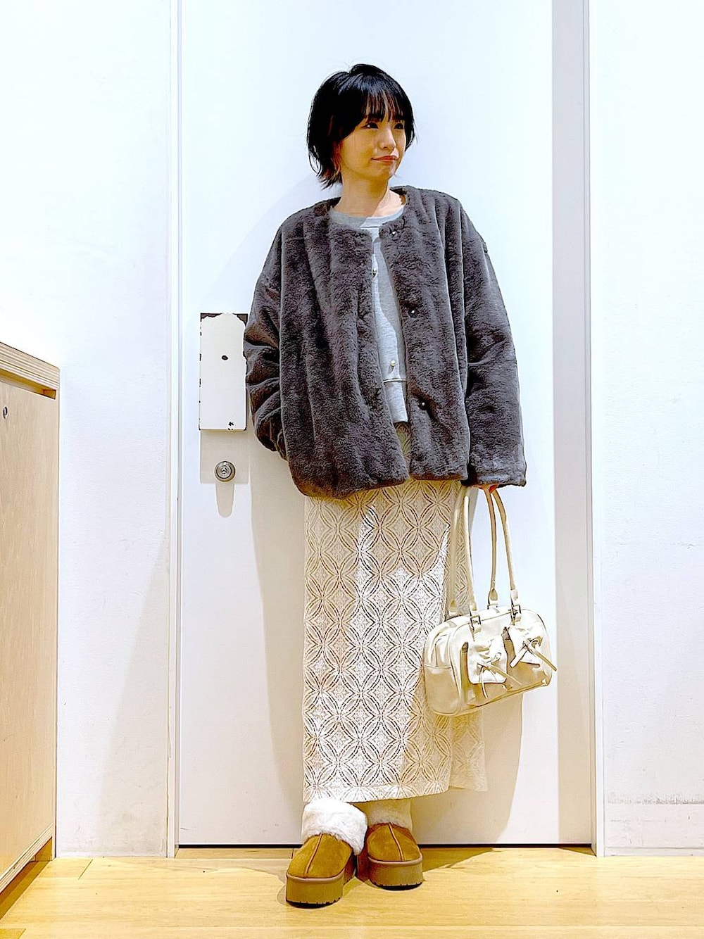 ベージュ系のスリッポン、ホワイト系のハンドバッグ、グレー系のスウェットを着用したレディースの秋コーディネートの1枚目の写真