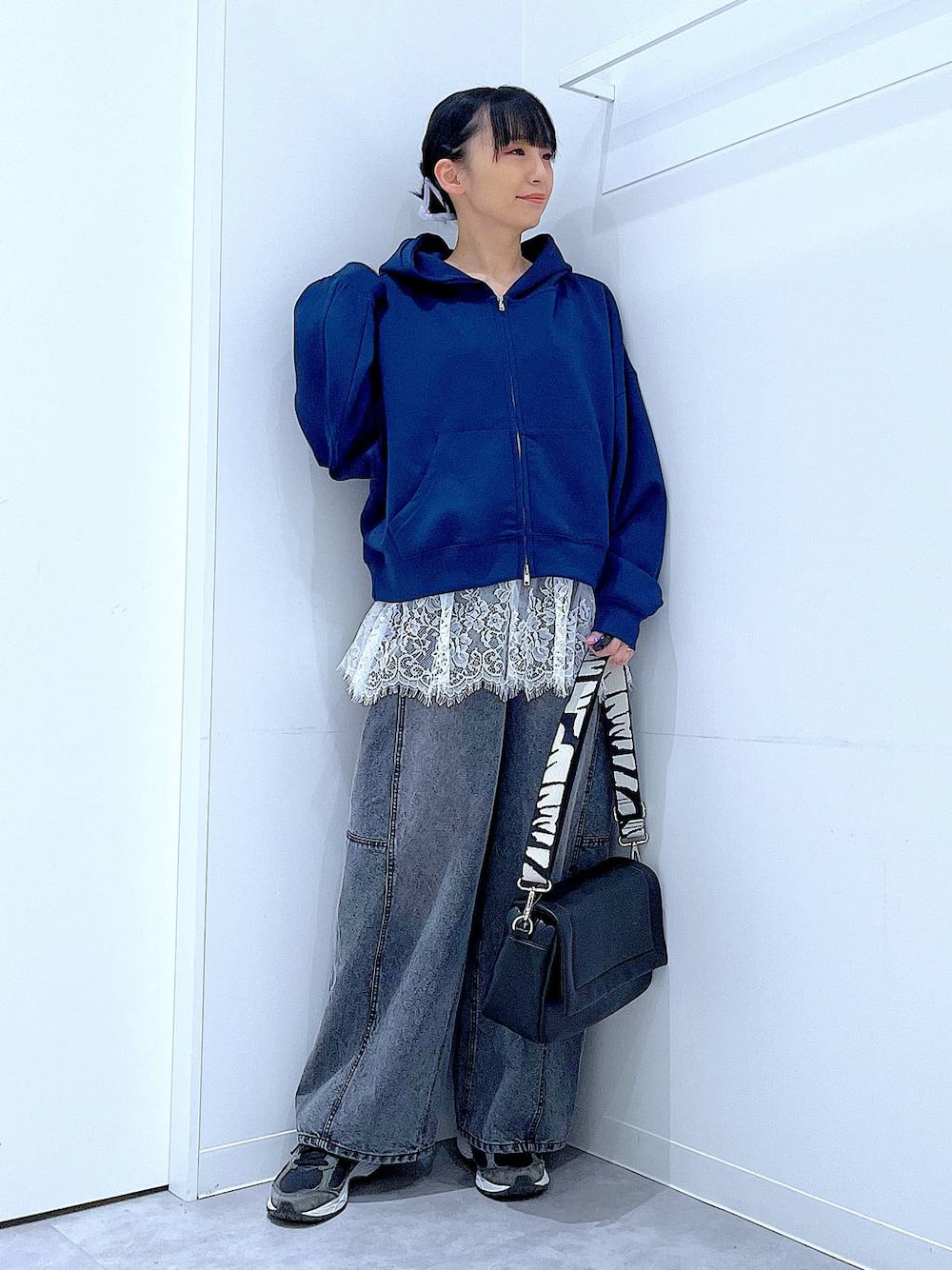 ブラック系のショルダーバッグ、ホワイト系のTシャツ/カットソー、ブラック系のデニムパンツを着用したレディースの春コーディネートの1枚目の写真