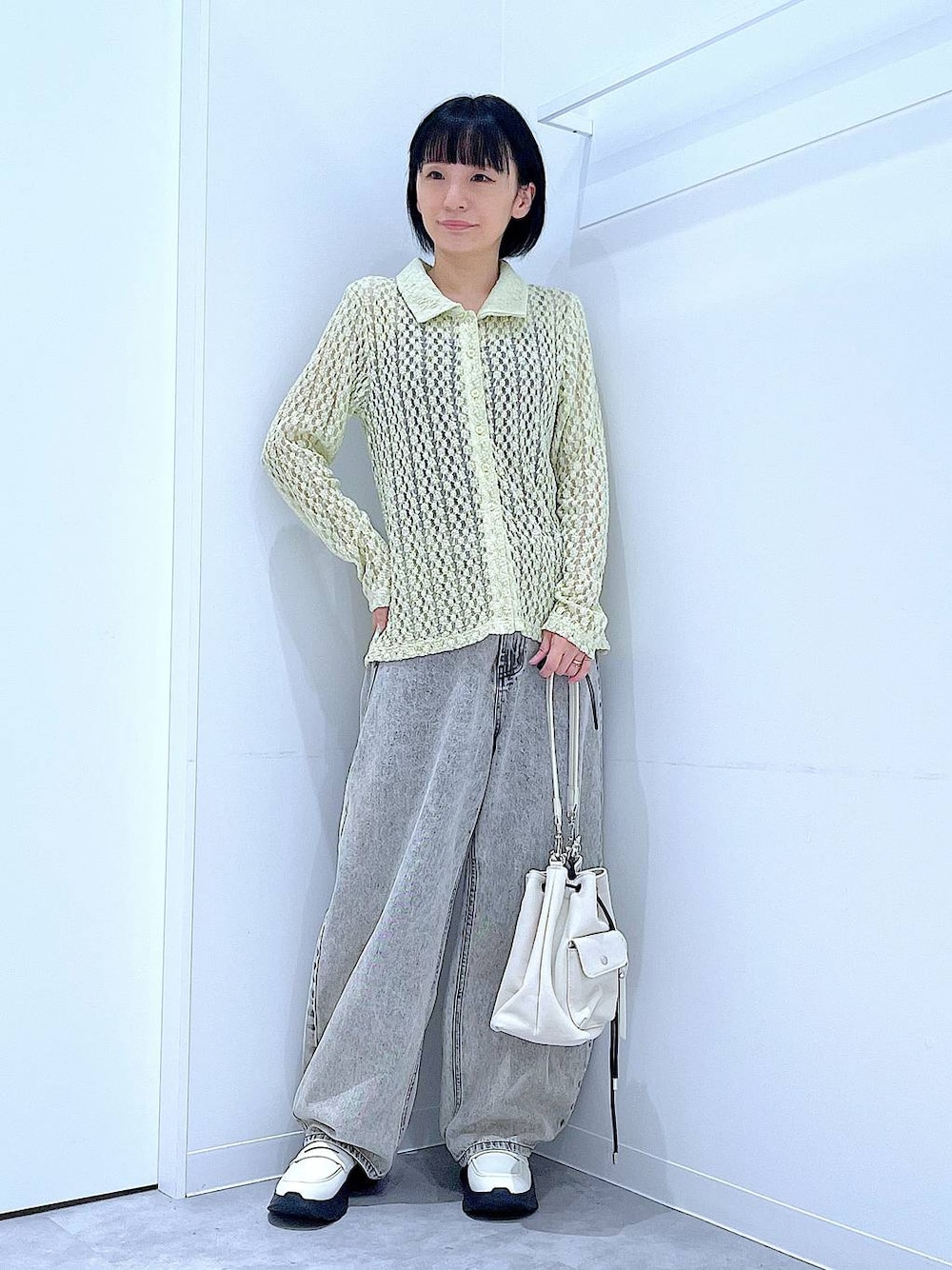 ベージュ系のデニムパンツ、ホワイト系のローファー、ホワイト系のショルダーバッグを着用したレディースの秋コーディネートの1枚目の写真