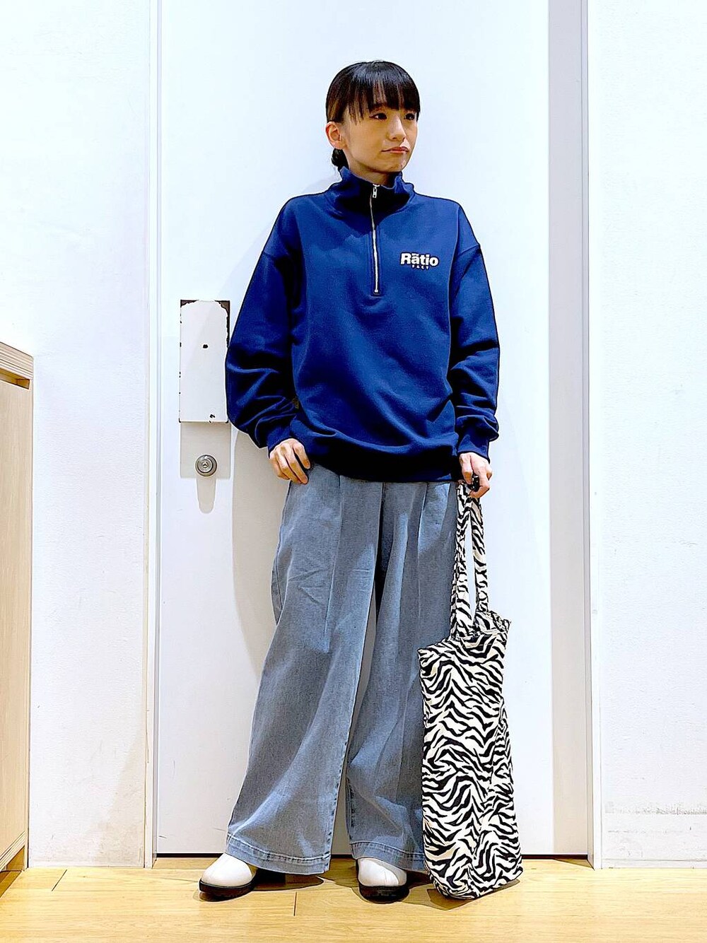 ブルー系のデニムパンツ、ブルー系のスウェット、ベージュ系のブーツを着用したレディースの春コーディネートの1枚目の写真