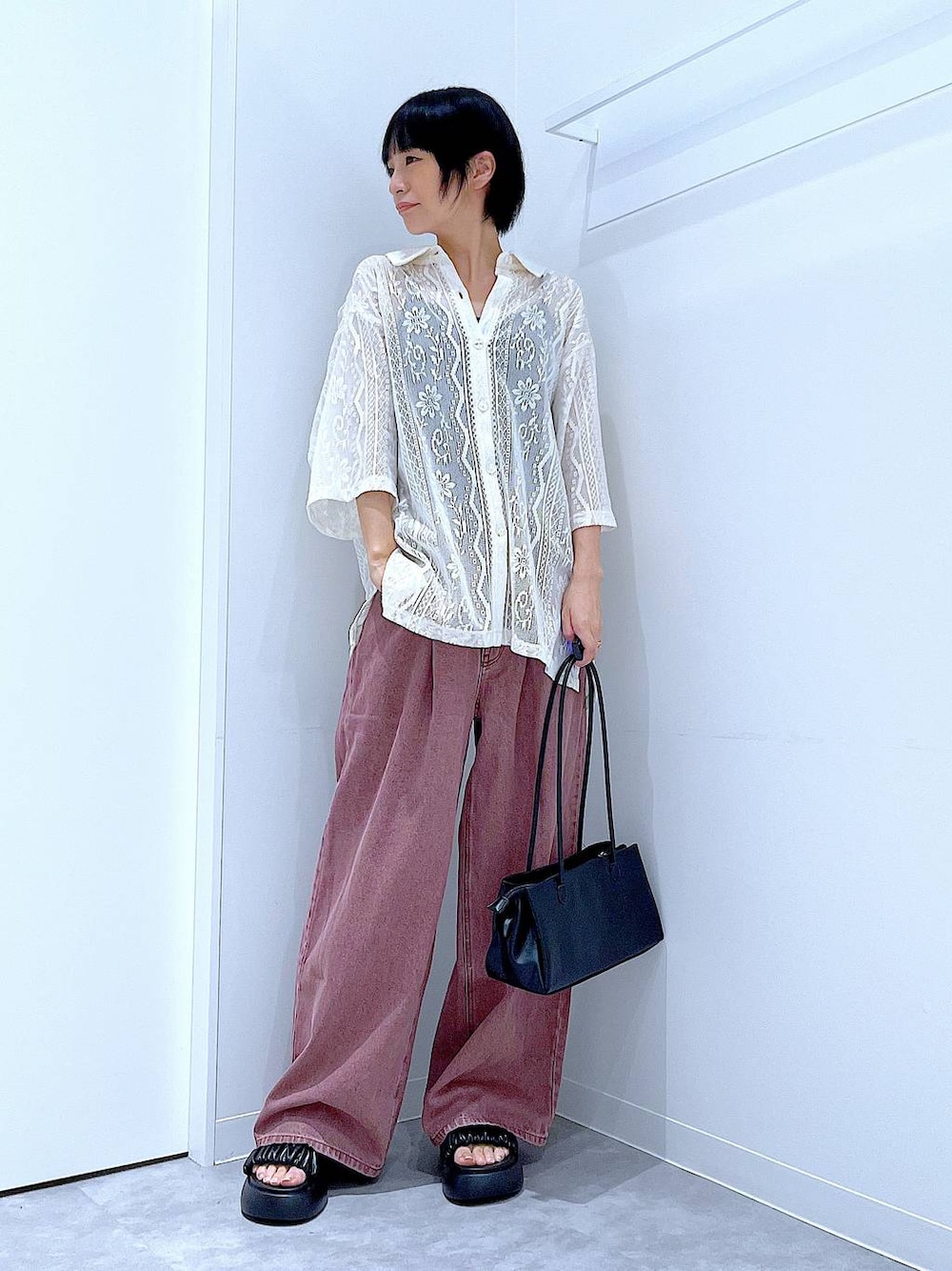 ブラック系のトートバッグ、ブラック系のサンダル、ホワイト系のシャツ/ブラウスを着用したレディースの夏コーディネートの1枚目の写真