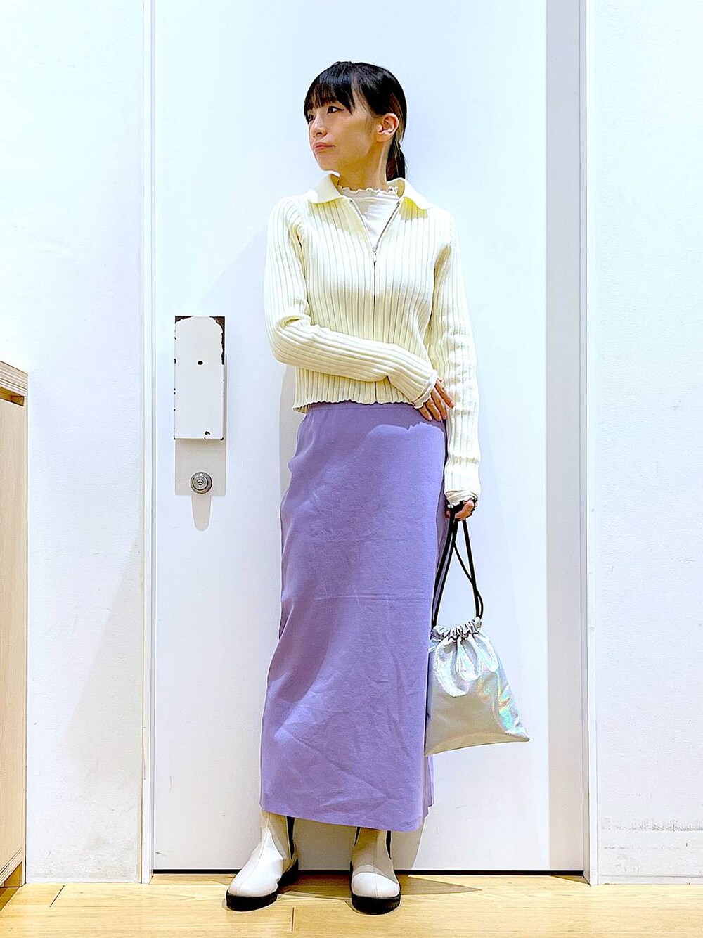 ホワイト系のTシャツ/カットソー、ベージュ系のカーディガン/ボレロ、ベージュ系のブーツを着用したレディースの春コーディネートの1枚目の写真