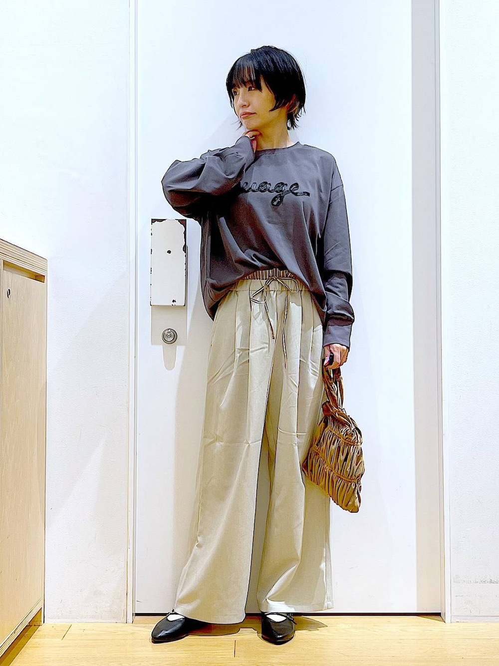 ブラック系のパンプス、イエロー系のショルダーバッグ、ベージュ系のその他パンツを着用したレディースの秋コーディネートの1枚目の写真