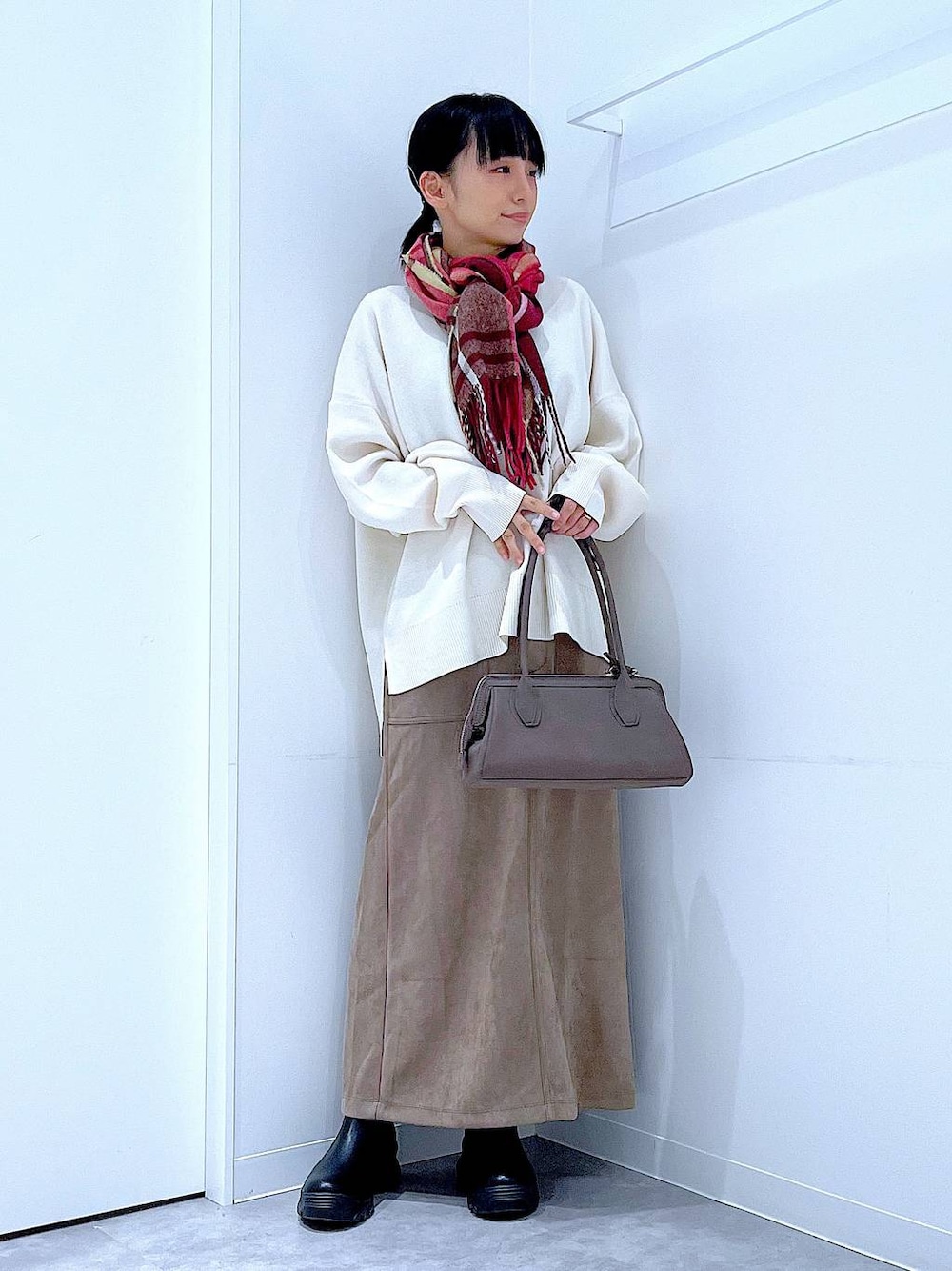 ブラック系のブーツ、ベージュ系のニット/セーター、ブラウン系のスカートを着用したレディースの秋コーディネートの1枚目の写真