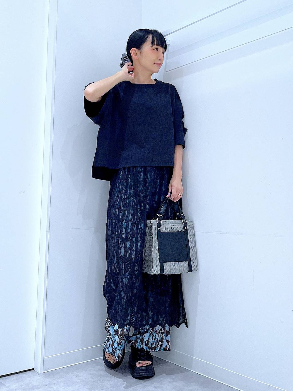 グレー系のショルダーバッグ、ブラック系のサンダル、ブラック系のTシャツ/カットソーを着用したレディースの夏コーディネートの1枚目の写真