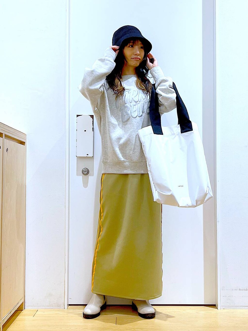 ベージュ系のスウェット、ベージュ系のブーツ、ホワイト系のトートバッグを着用したレディースの冬コーディネートの1枚目の写真