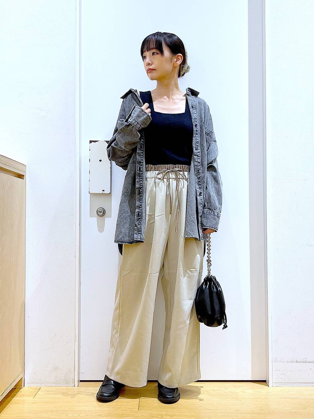 ブラック系のショルダーバッグ、ブラック系のローファー、ブラック系のニット/セーターを着用したレディースの秋コーディネートの1枚目の写真