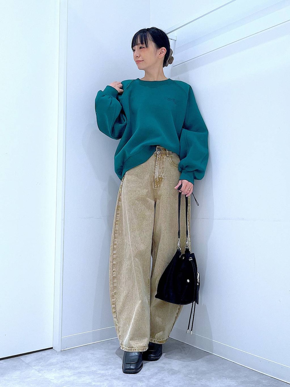 ベージュ系のデニムパンツ、ブラック系のショルダーバッグ、ブラック系のブーツを着用したレディースの冬コーディネートの1枚目の写真