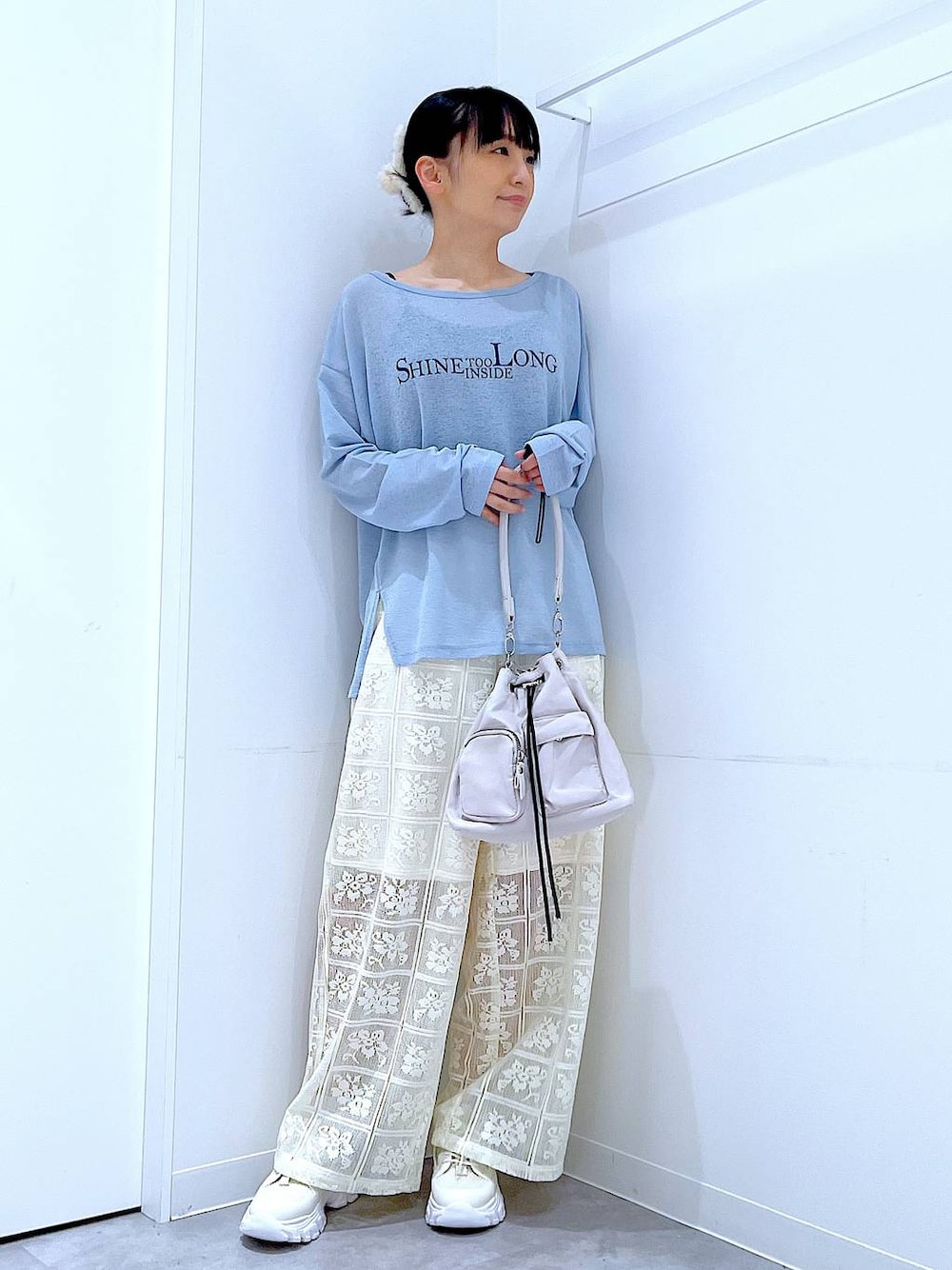ブルー系のTシャツ/カットソー、ホワイト系のスニーカー、ホワイト系のショルダーバッグを着用したレディースの春コーディネートの1枚目の写真