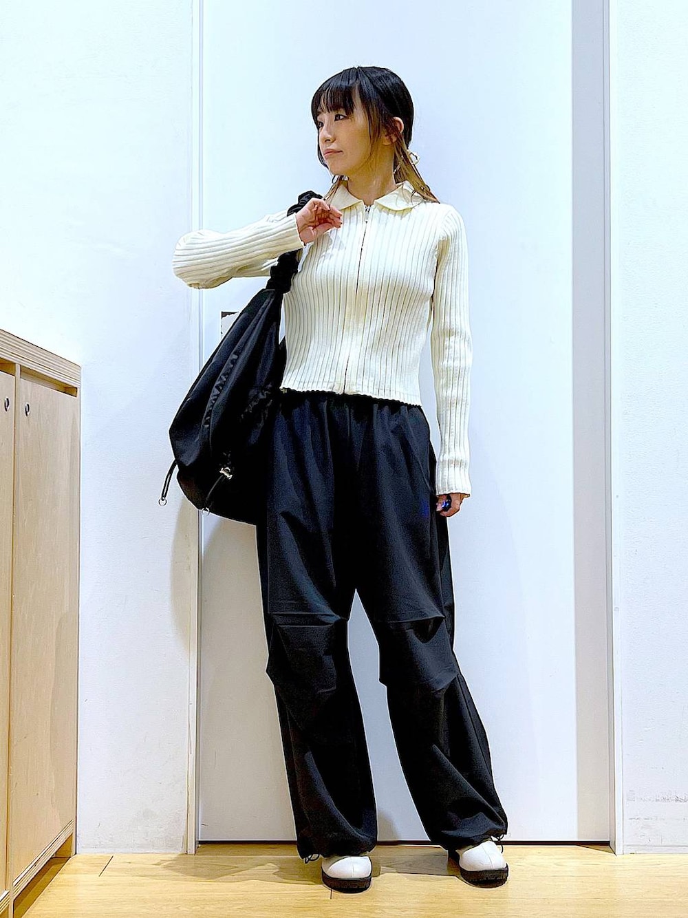 ブラック系のその他パンツ、ベージュ系のカーディガン/ボレロ、ベージュ系のブーツを着用したレディースの春コーディネートの1枚目の写真