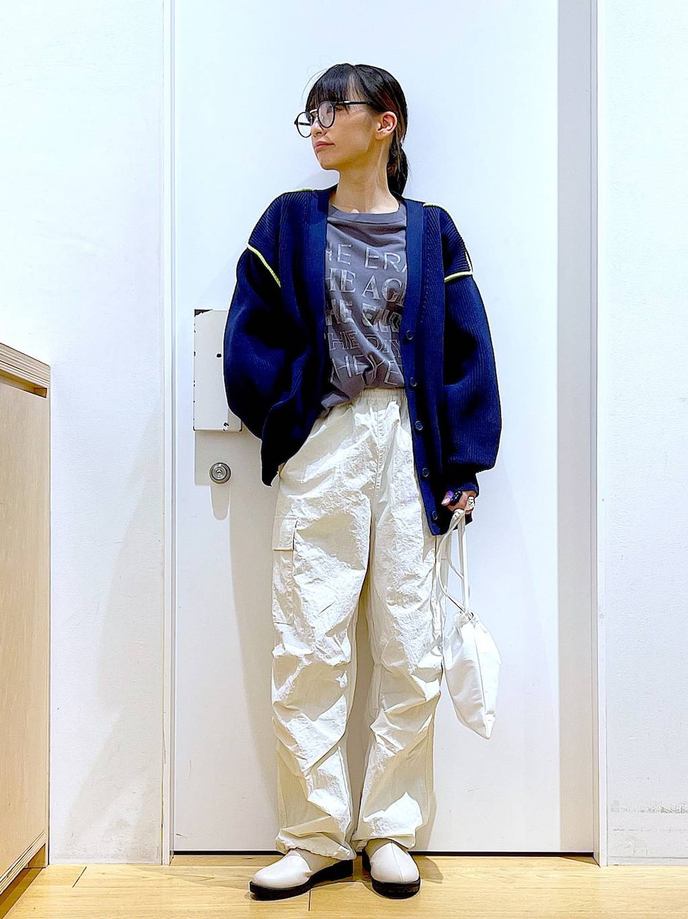 グレー系のTシャツ/カットソー、ベージュ系のブーツ、ホワイト系のショルダーバッグを着用したレディースの冬コーディネートの1枚目の写真