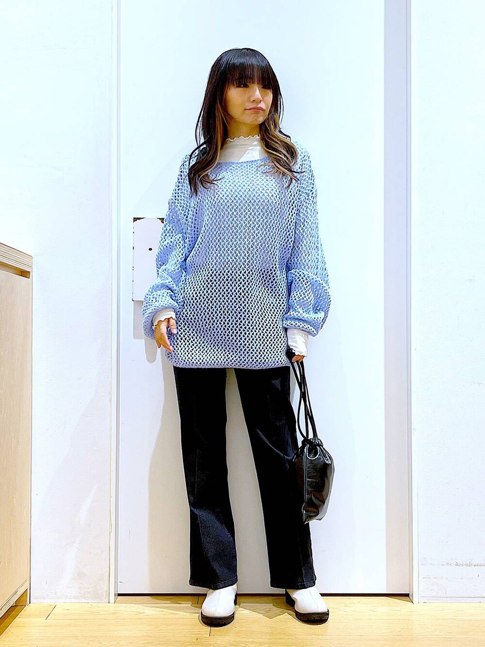 グレー系のデニムパンツ、ホワイト系のTシャツ/カットソー、ブルー系のニット/セーターを着用したレディースの冬コーディネートの1枚目の写真