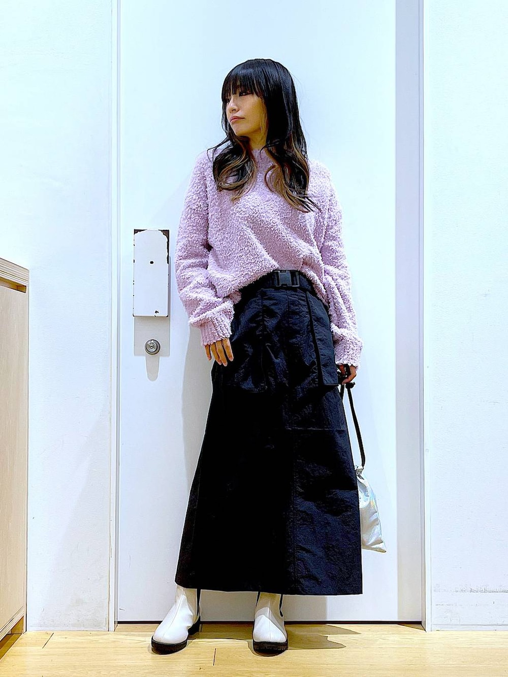 パープル系のニット/セーター、ベージュ系のブーツ、その他のショルダーバッグを着用したレディースの冬コーディネートの1枚目の写真