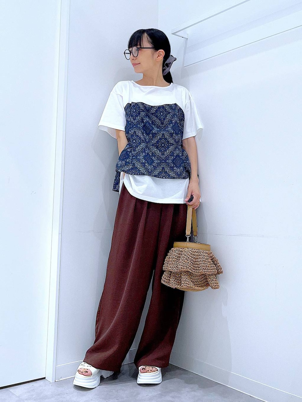 ベージュ系のショルダーバッグ、ホワイト系のサンダル、ホワイト系のTシャツ/カットソーを着用したレディースの夏コーディネートの1枚目の写真