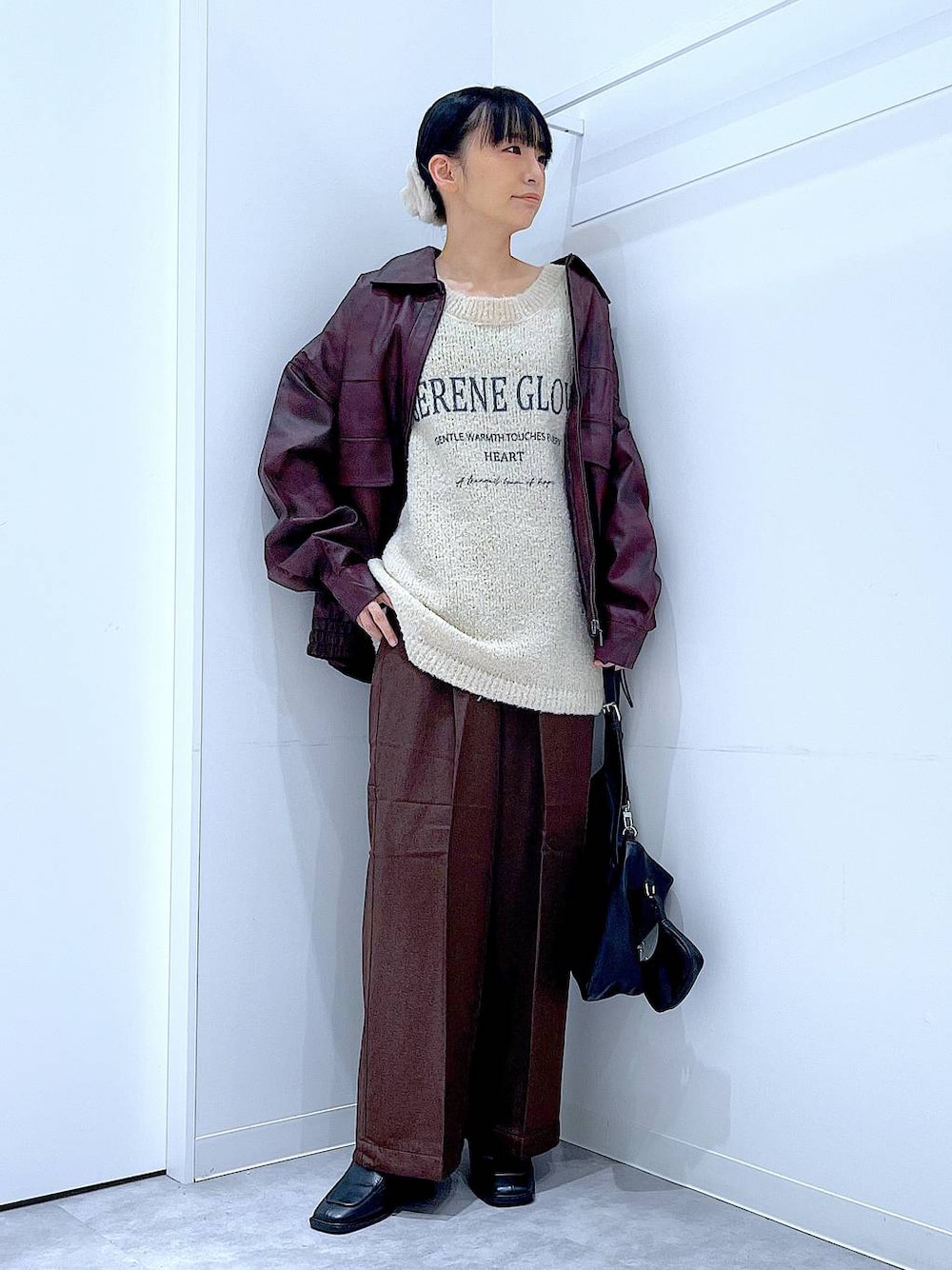 レッド系のブルゾン、ホワイト系のニット/セーター、ブラック系のブーツを着用したレディースの秋コーディネートの1枚目の写真