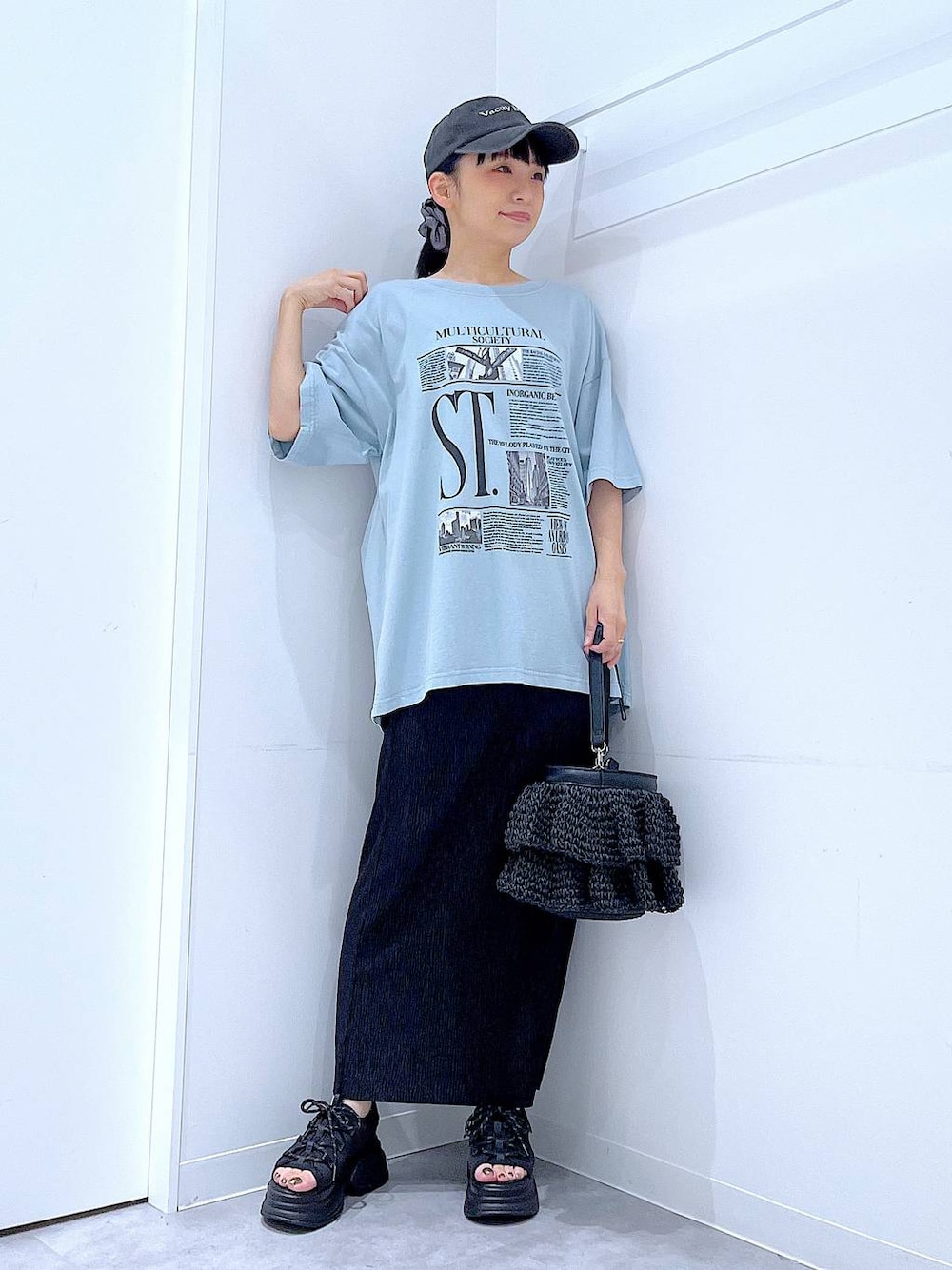 ブラック系のショルダーバッグ、ブラック系のサンダル、ブルー系のTシャツ/カットソーを着用したレディースの夏コーディネートの1枚目の写真
