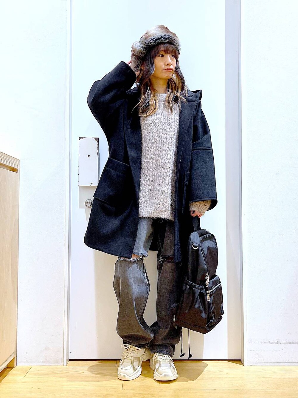 ブラック系のバックパック/リュック、ブラック系のその他アウター、ベージュ系のスニーカーを着用したレディースの冬コーディネートの1枚目の写真