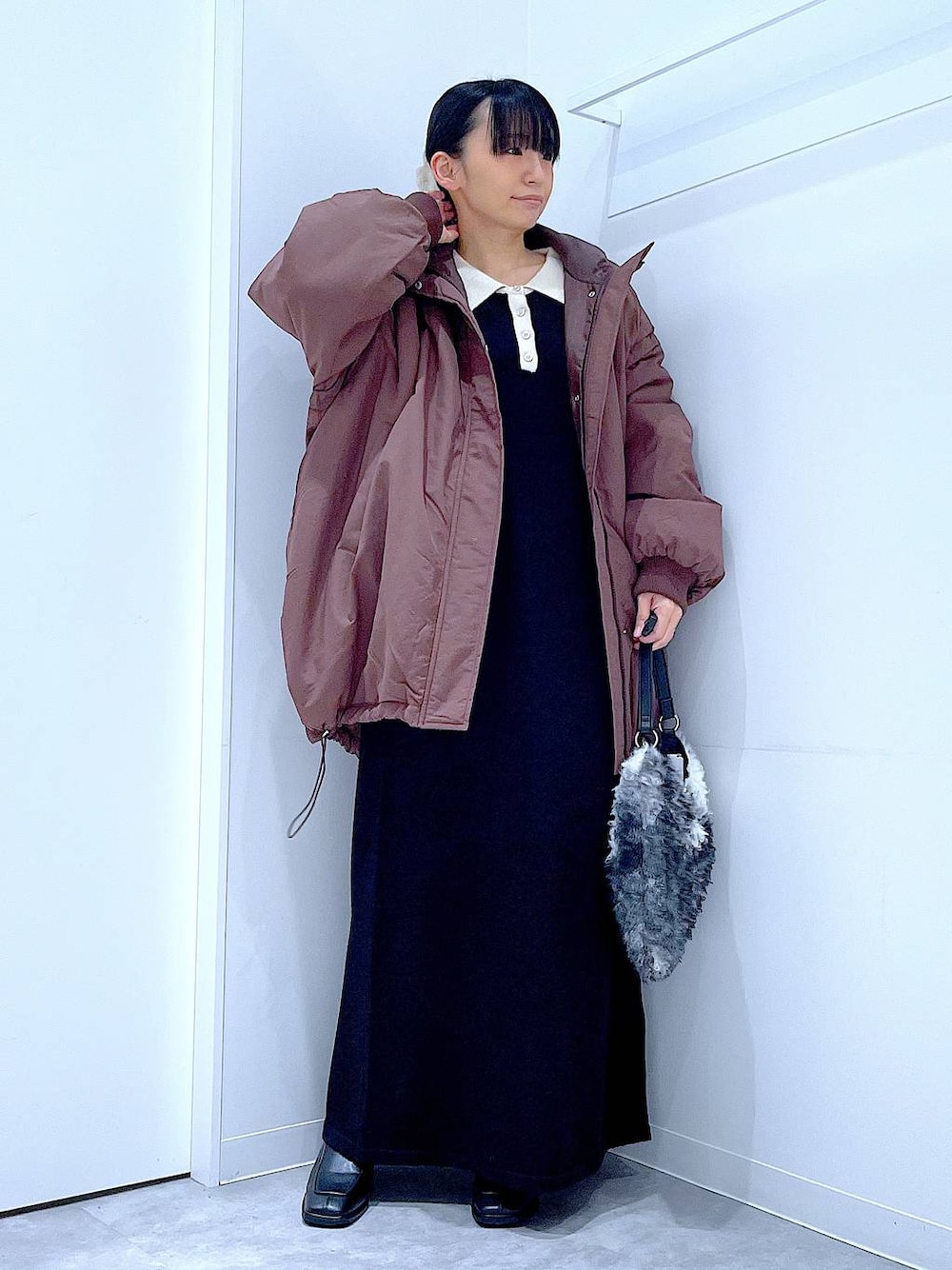 ブラウン系のブルゾン、ブラック系のブーツ、ブラック系のショルダーバッグを着用したレディースの冬コーディネートの1枚目の写真