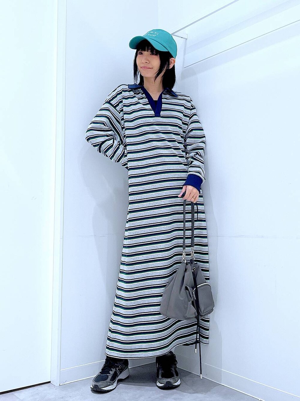 グリーン系のキャップを着用したレディースの春コーディネートの1枚目の写真