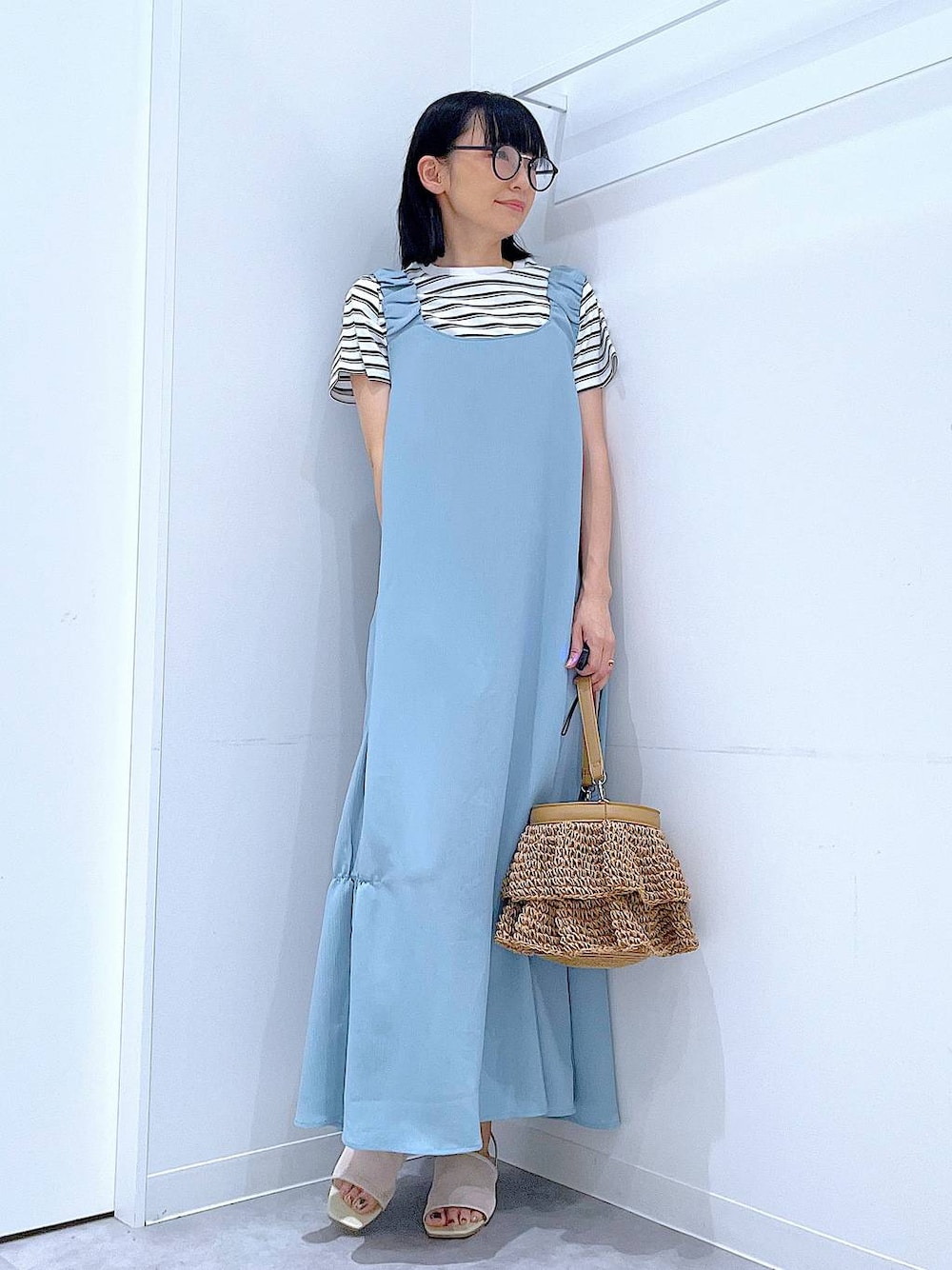 ベージュ系のショルダーバッグ、ホワイト系のサンダル、ベージュ系のTシャツ/カットソーを着用したレディースの夏コーディネートの1枚目の写真