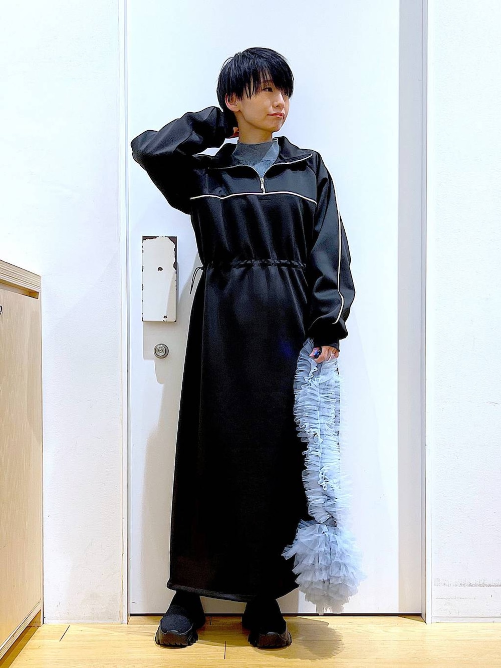 ブラック系のブーツ、ブルー系のショルダーバッグ、ブルー系のニット/セーターを着用したレディースの冬コーディネートの1枚目の写真