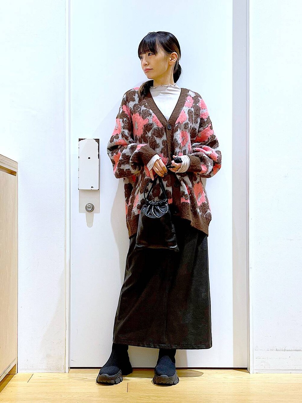 グレー系のTシャツ/カットソー、ブラック系のブーツ、ブラック系のスカートを着用したレディースの冬コーディネートの1枚目の写真