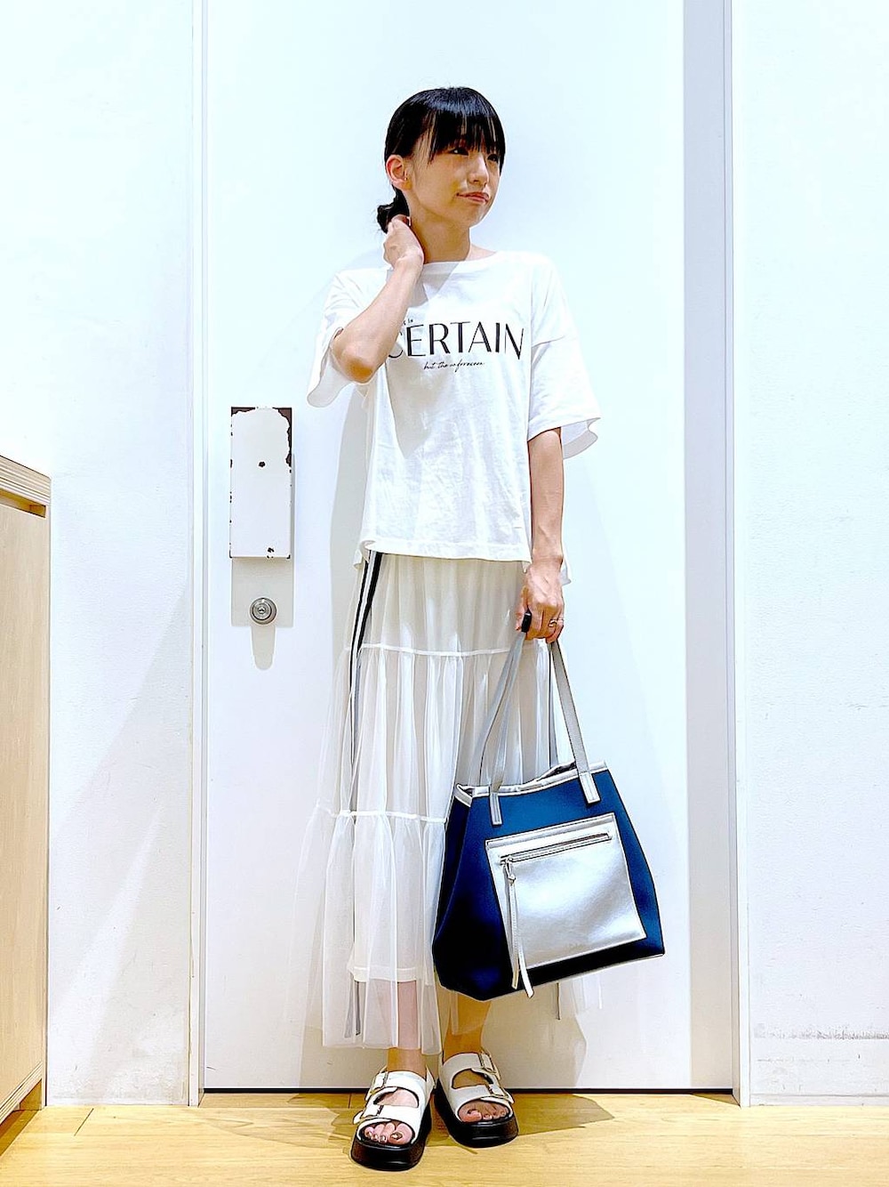 ホワイト系のサンダル、ホワイト系のスカート、ホワイト系のTシャツ/カットソーを着用したレディースの夏コーディネートの1枚目の写真