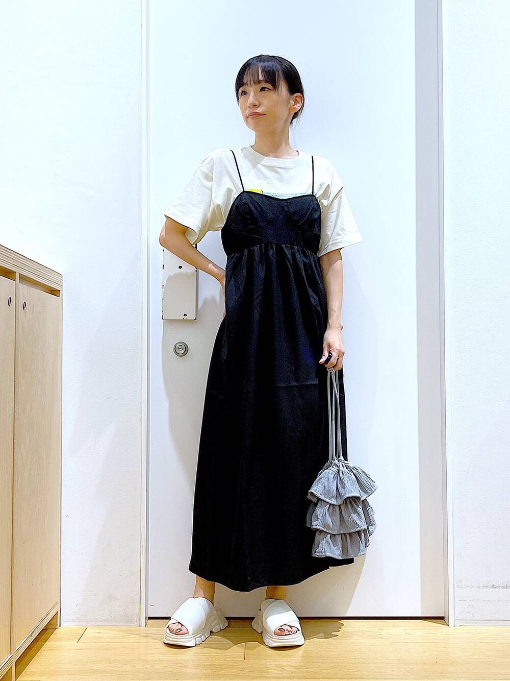 ホワイト系のサンダル、ベージュ系のTシャツ/カットソー、ブラック系のワンピースを着用したレディースの夏コーディネートの1枚目の写真