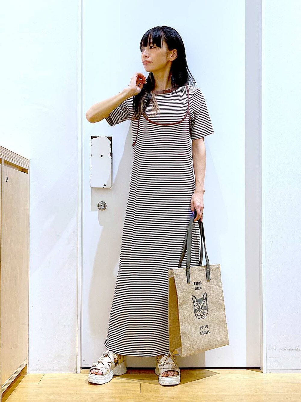 ベージュ系のサンダル、グレー系のトートバッグ、ベージュ系のワンピースを着用したレディースの夏コーディネートの1枚目の写真