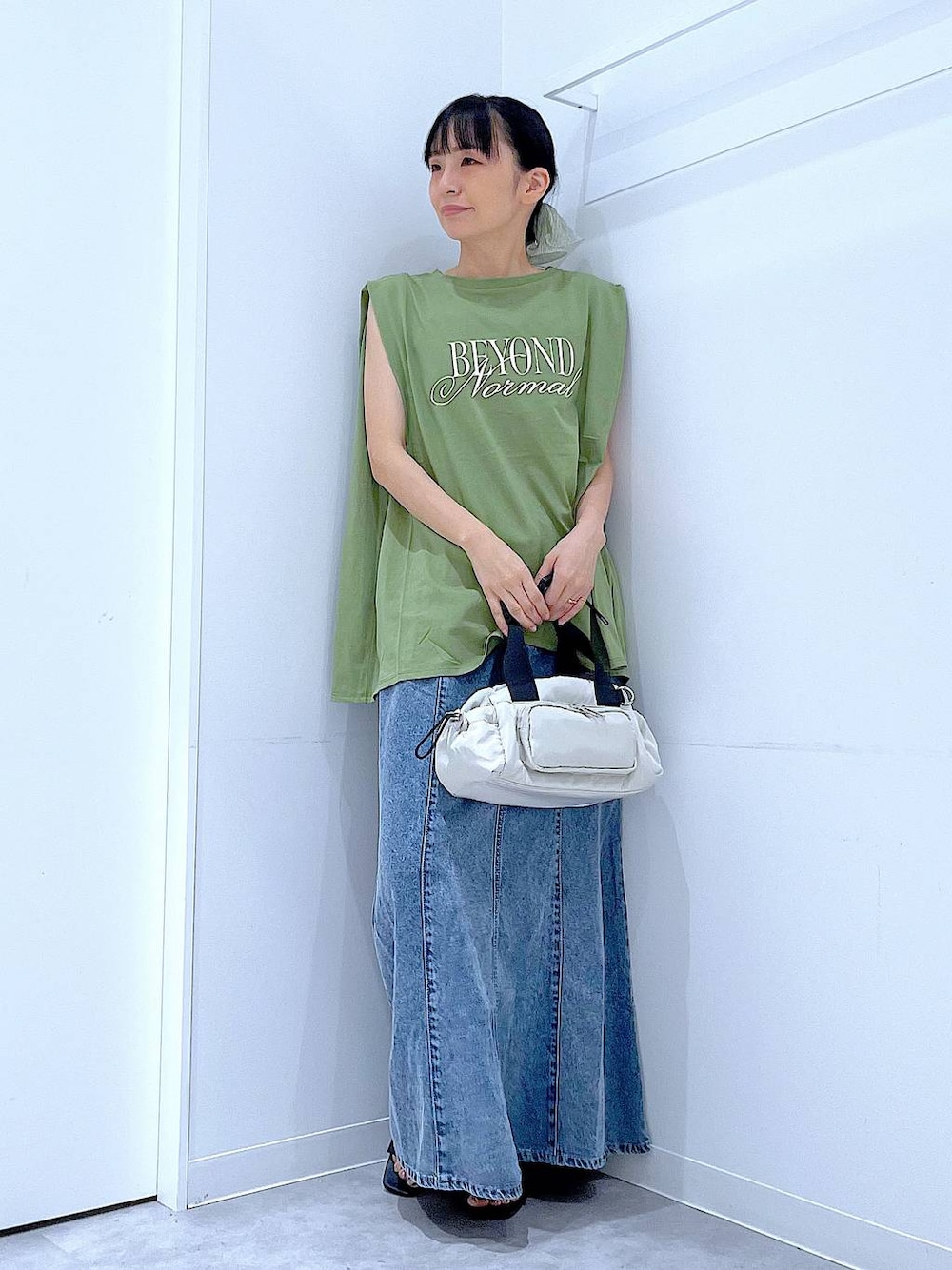 ブラック系のサンダル、ホワイト系のショルダーバッグ、グリーン系のTシャツ/カットソーを着用したレディースの夏コーディネートの1枚目の写真