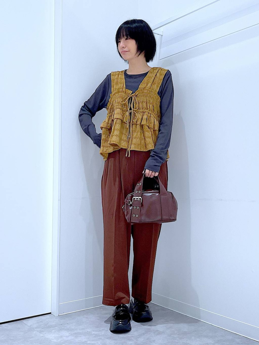 グレー系のTシャツ/カットソー、ブラック系のローファー、ブラック系のショルダーバッグを着用したレディースの秋コーディネートの1枚目の写真