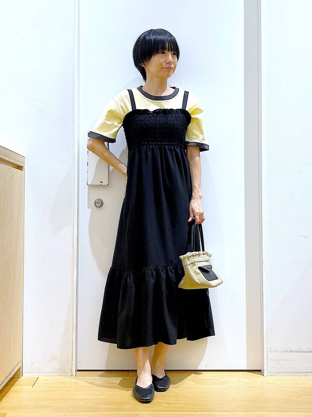 ブラック系のパンプス、ベージュ系のショルダーバッグ、ブラック系のワンピースを着用したレディースの夏コーディネートの1枚目の写真