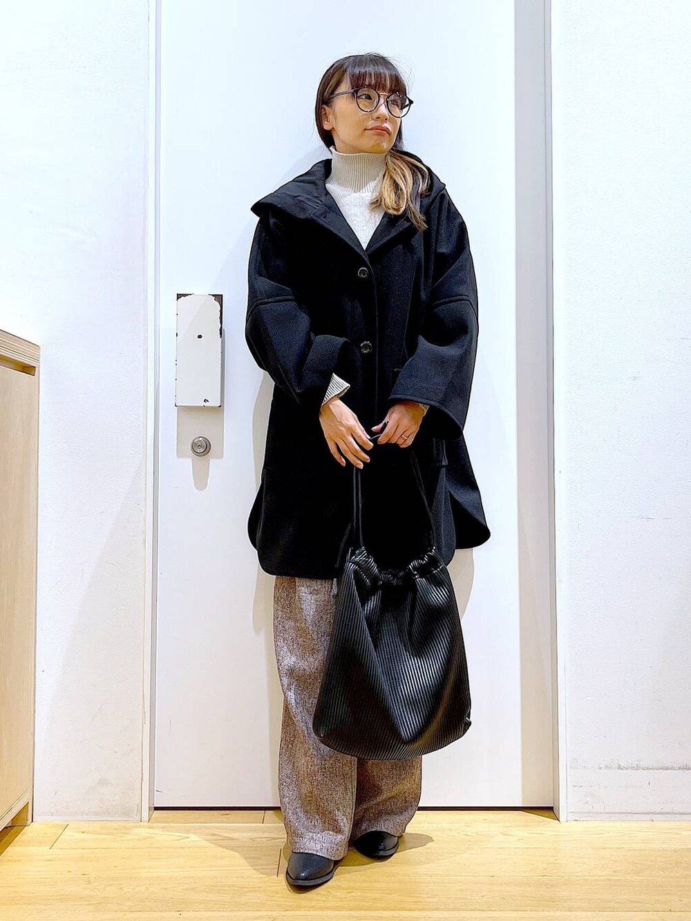 ブラック系のその他アウター、ブラック系のブーツ、ブラック系のトートバッグを着用したレディースの冬コーディネートの1枚目の写真