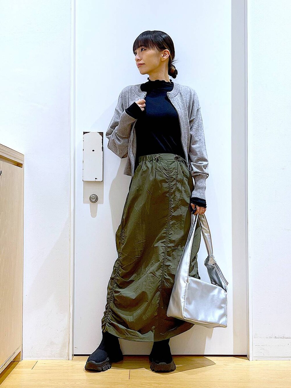 ブラック系のTシャツ/カットソー、グレー系のカーディガン/ボレロ、ブラック系のブーツを着用したレディースの冬コーディネートの1枚目の写真