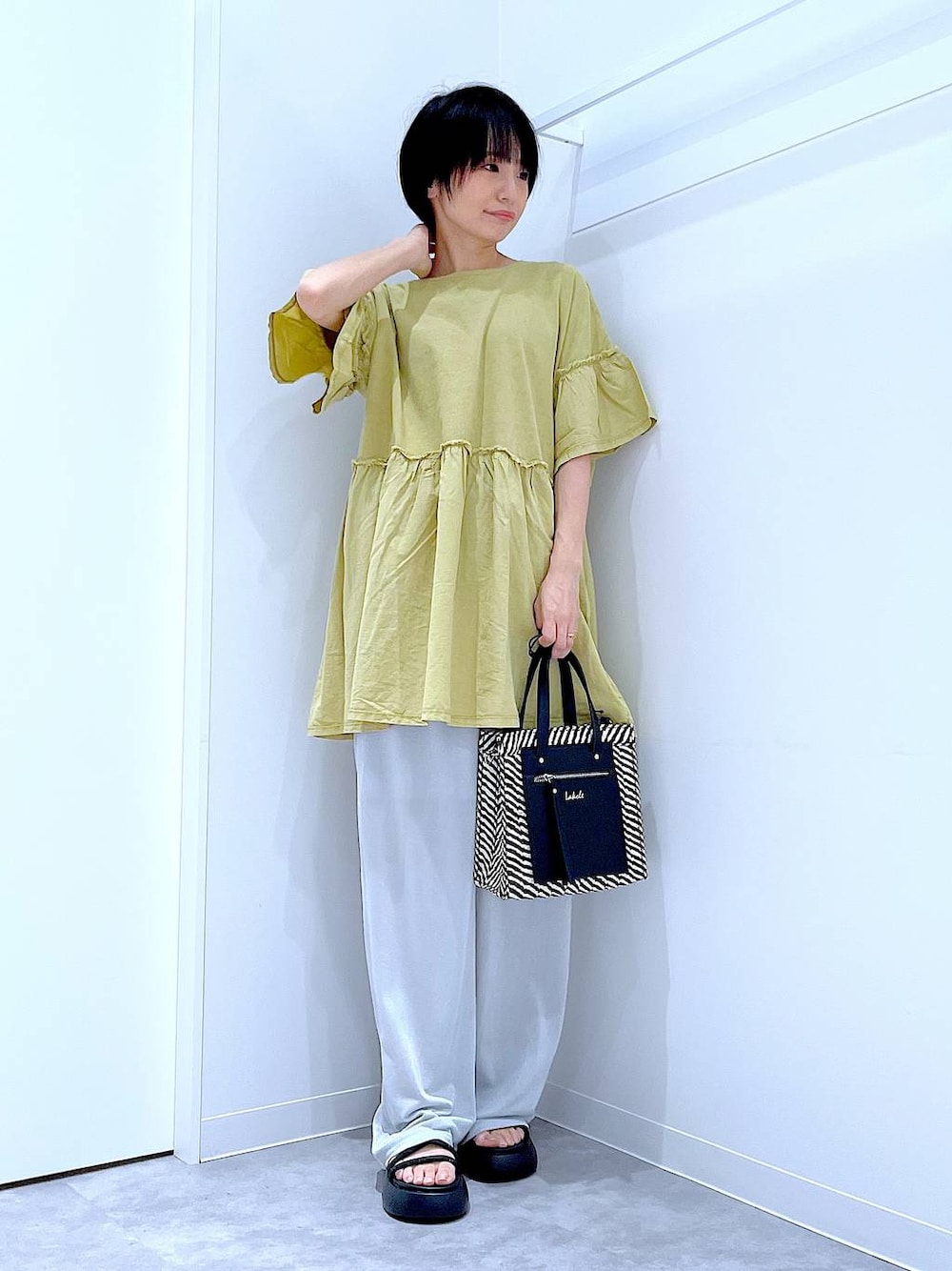 ブラック系のショルダーバッグ、ブラック系のサンダル、グレー系のその他パンツを着用したレディースの夏コーディネートの1枚目の写真