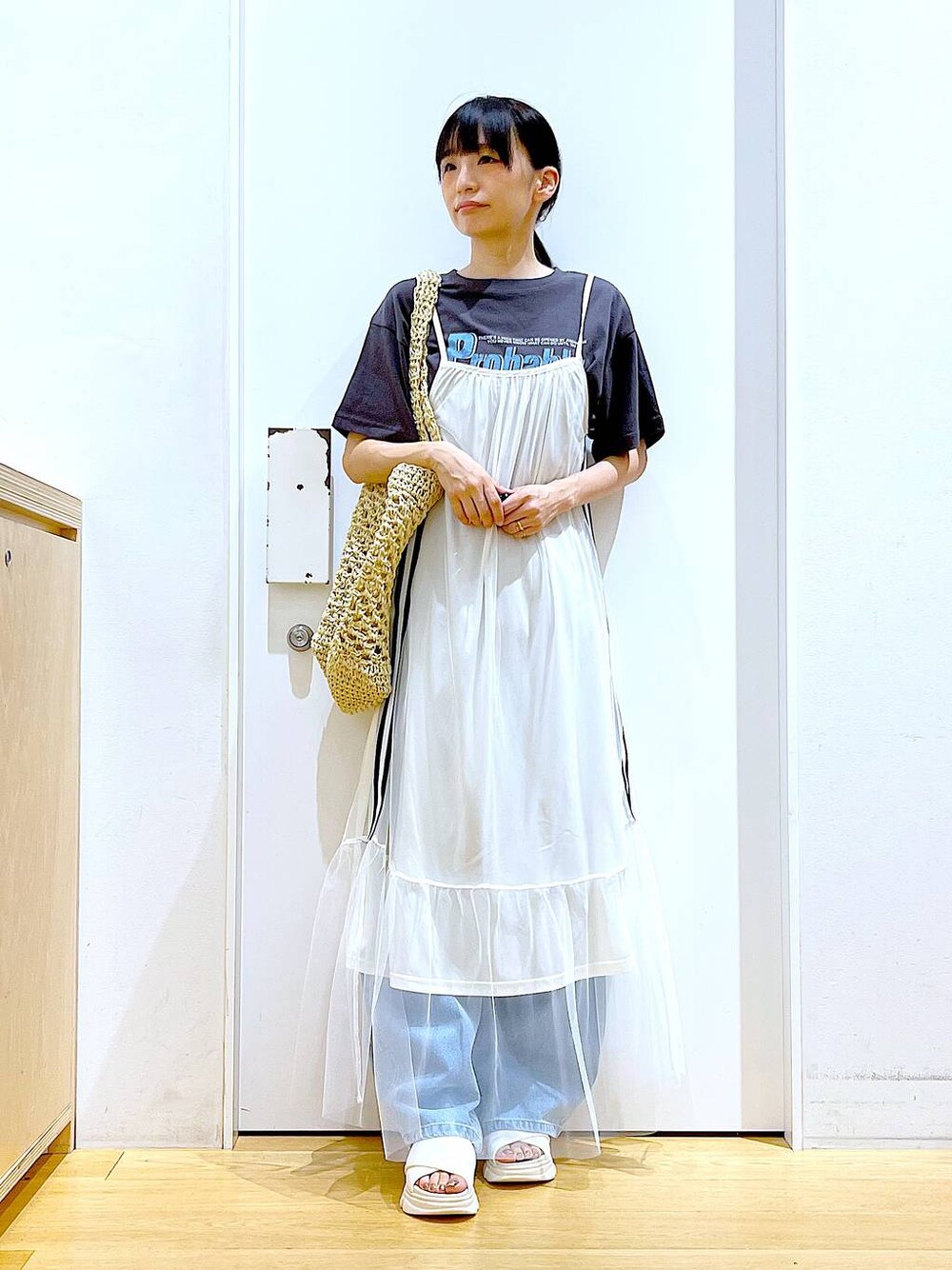 ホワイト系のサンダル、ブルー系のデニムパンツ、ホワイト系のトートバッグを着用したレディースの夏コーディネートの1枚目の写真