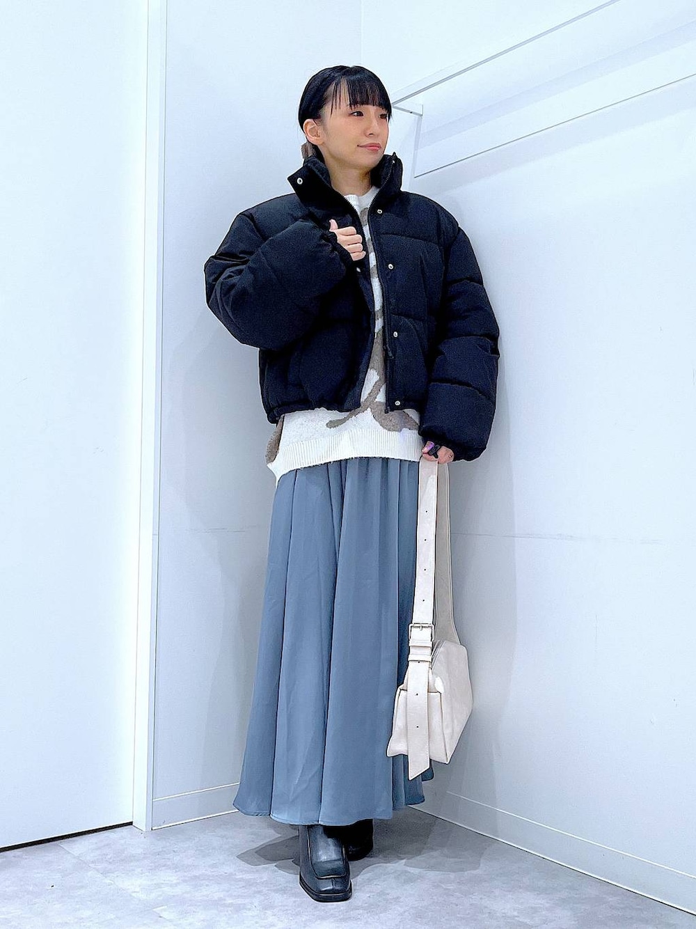 ブラック系のブルゾン、ブラック系のブーツ、ベージュ系のニット/セーターを着用したレディースの冬コーディネートの1枚目の写真