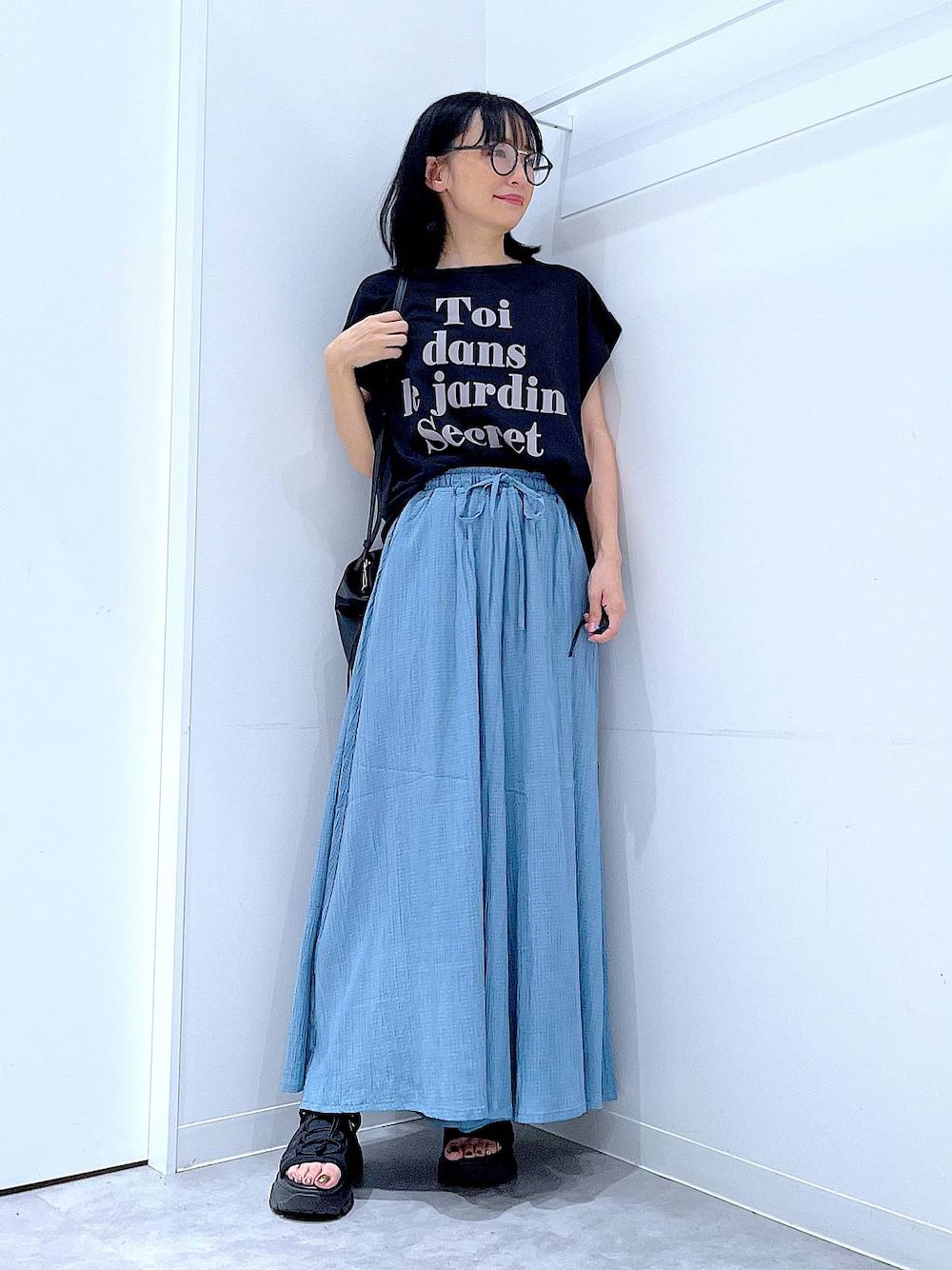 ブラック系のハンドバッグ、ブラック系のTシャツ/カットソー、その他のサングラスを着用したレディースの夏コーディネートの1枚目の写真