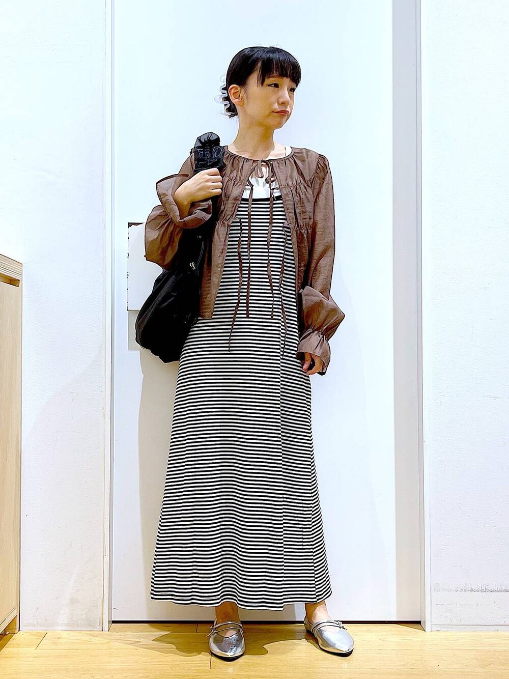 ブラック系のワンピース、シルバー系のパンプス、ブラック系のショルダーバッグを着用したレディースの夏コーディネートの1枚目の写真