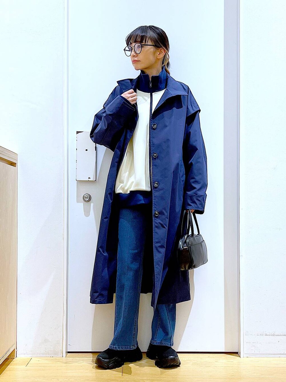 ブラック系のショルダーバッグ、ブルー系のデニムパンツ、ブルー系のその他アウターを着用したレディースの冬コーディネートの1枚目の写真