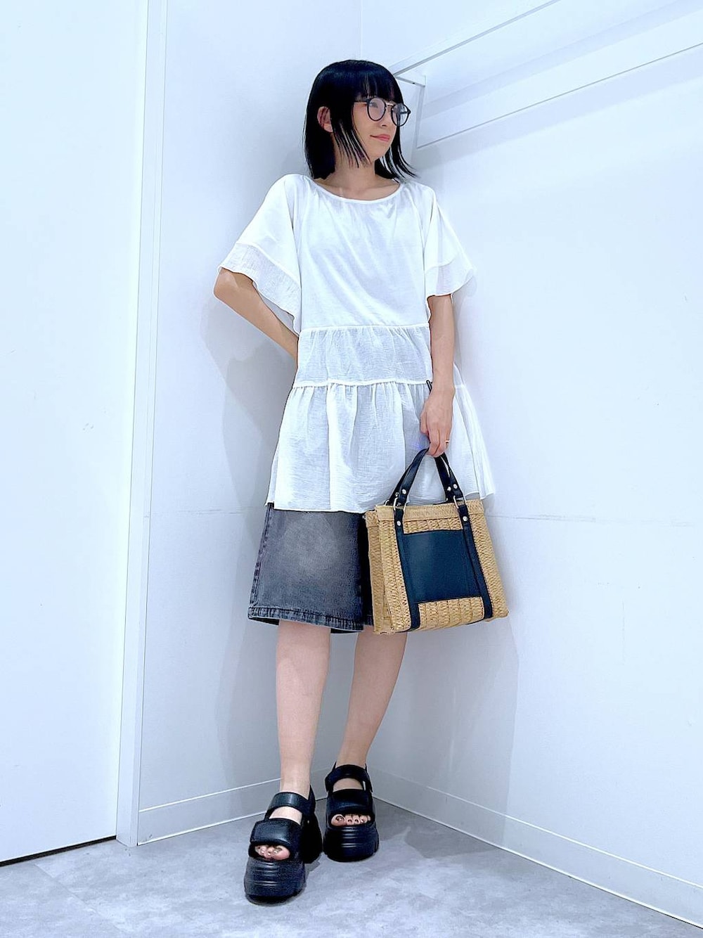 ベージュ系のショルダーバッグ、ブラック系のサンダル、ホワイト系のTシャツ/カットソーを着用したレディースの夏コーディネートの1枚目の写真