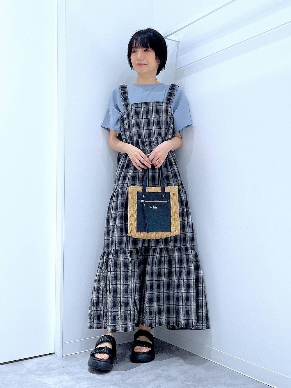 ベージュ系のショルダーバッグ、ブラック系のサンダル、ブラック系のワンピースを着用したレディースの夏コーディネートの1枚目の写真