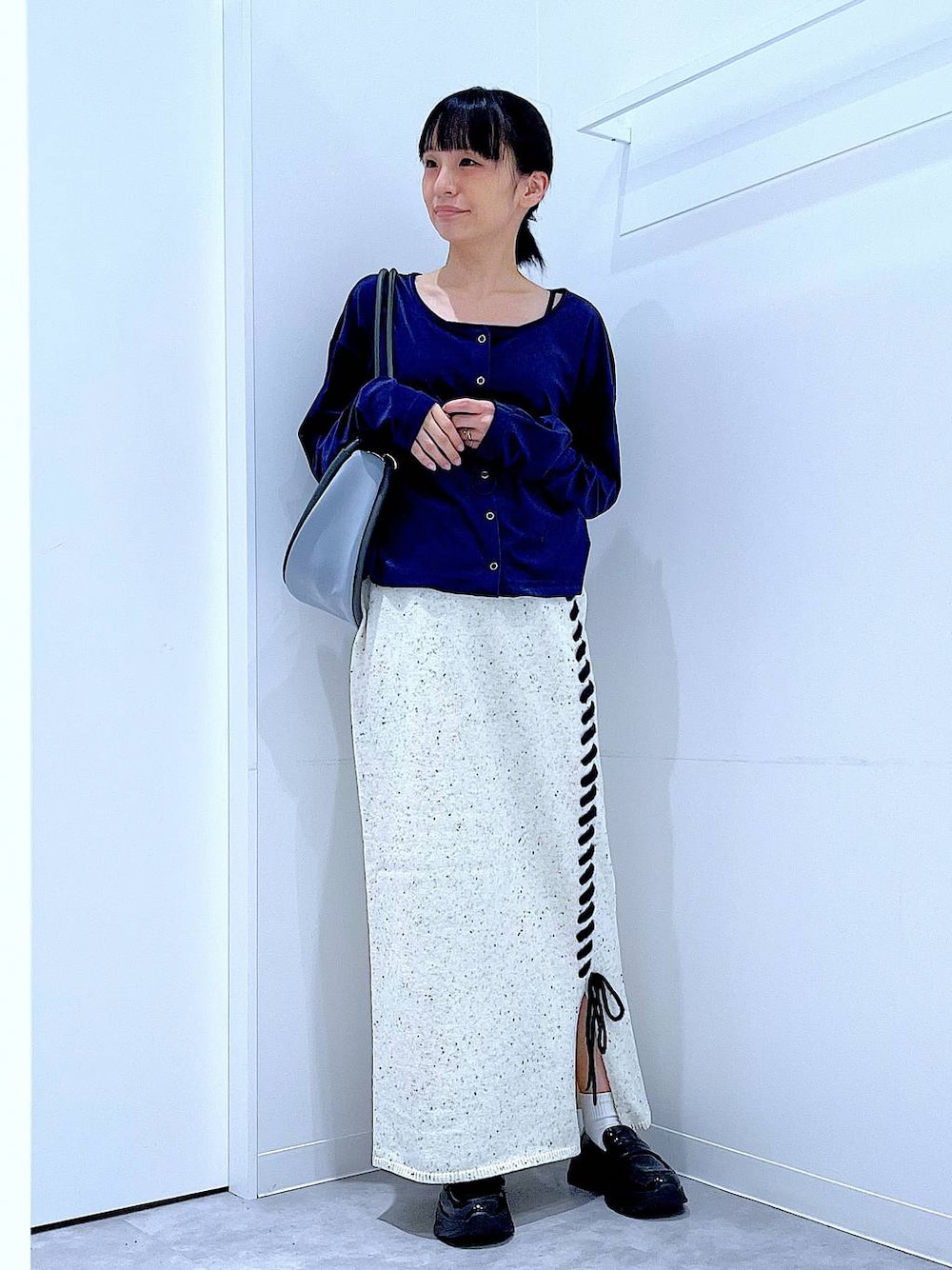 ブラック系のローファー、ブルー系のTシャツ/カットソー、グレー系のショルダーバッグを着用したレディースの秋コーディネートの1枚目の写真