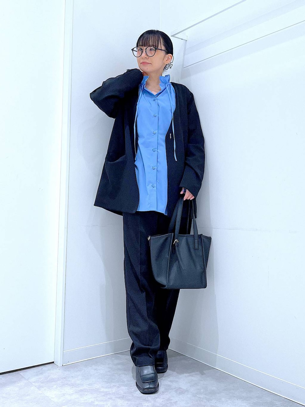 ブラック系のブーツ、ブラック系のトートバッグ、ブラック系のノーカラージャケットを着用したレディースの冬コーディネートの1枚目の写真